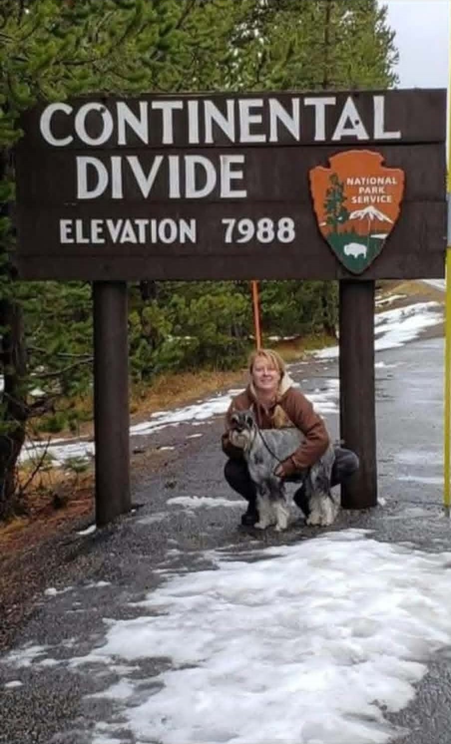 Amy with two Standard Schnauzers beneath the Continental Divide sign